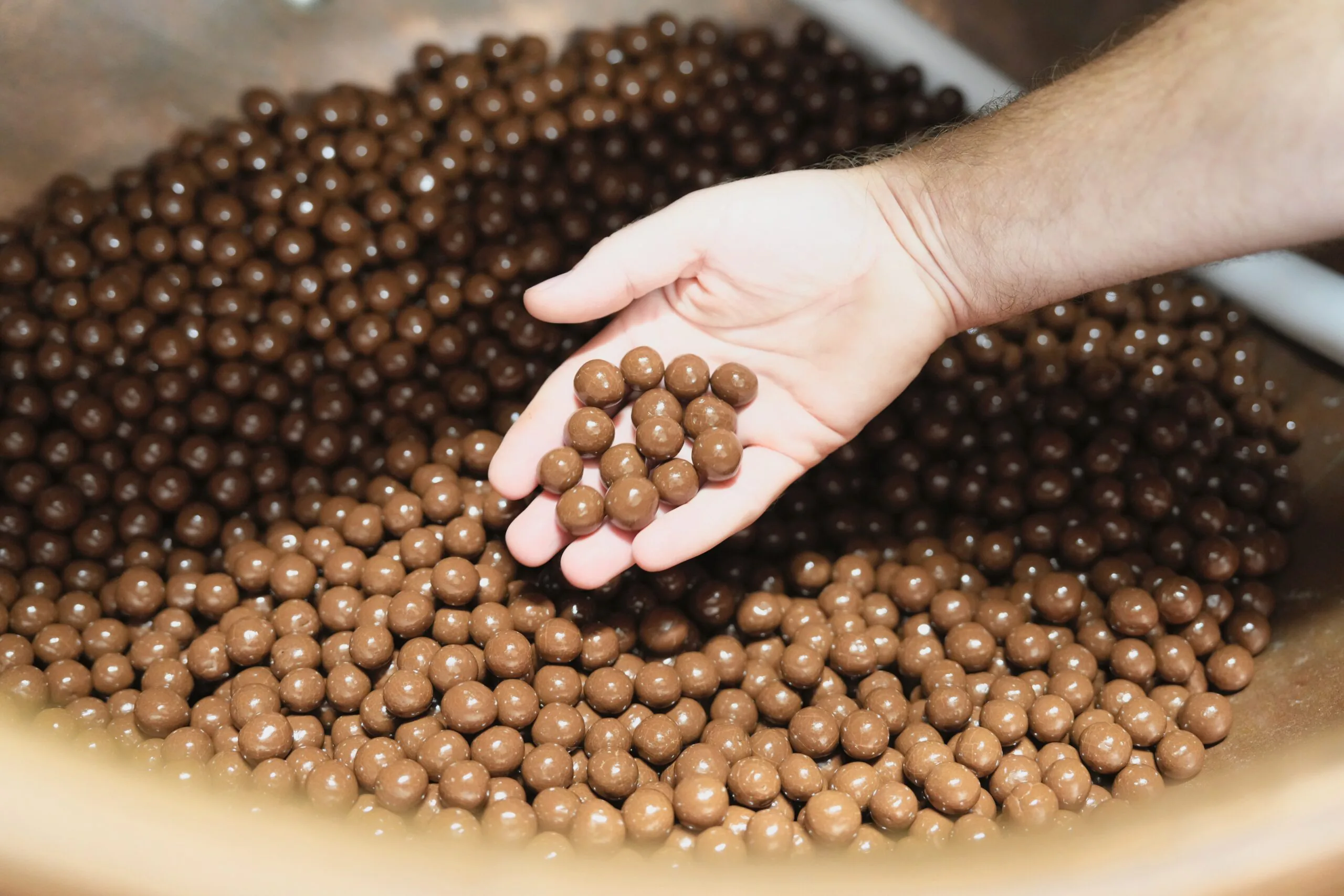 Billes enrobées de chocolat tenues dans la main